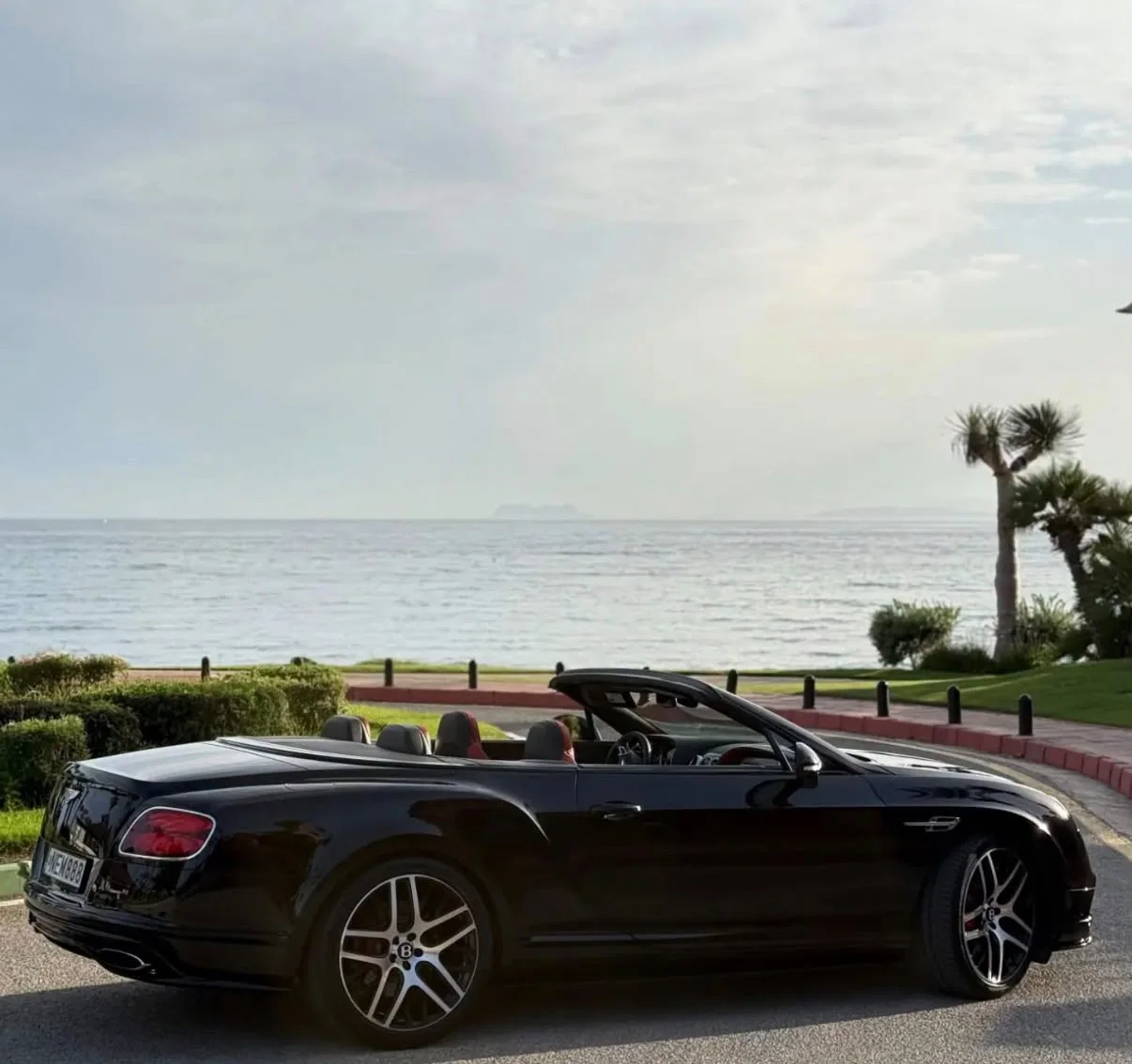 Black Bentley Continental GTC with its roof open in Marbella